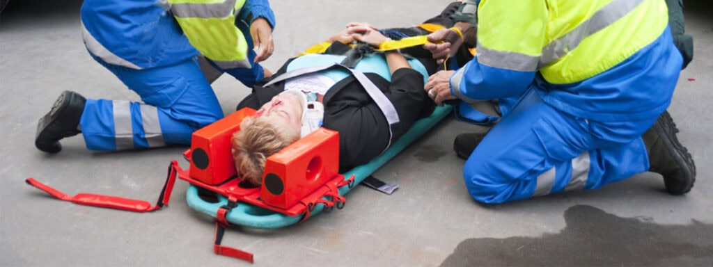 Emergency responders secure an injured person to a spine board