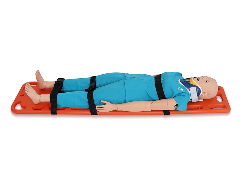 Medical training mannequin secured on an orange spine board with straps and a cervical collar for immobilization practice.
