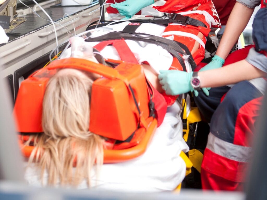 Patient secured with head immobilizer on stretcher