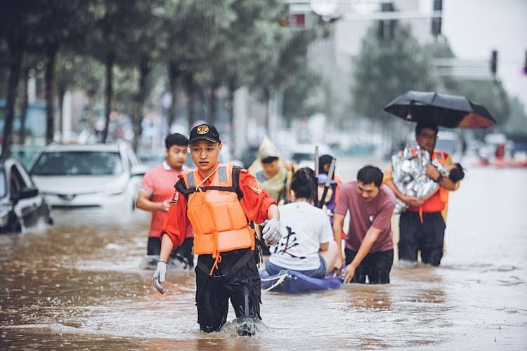 Rescue team evacuating people during city flood with safety equipment