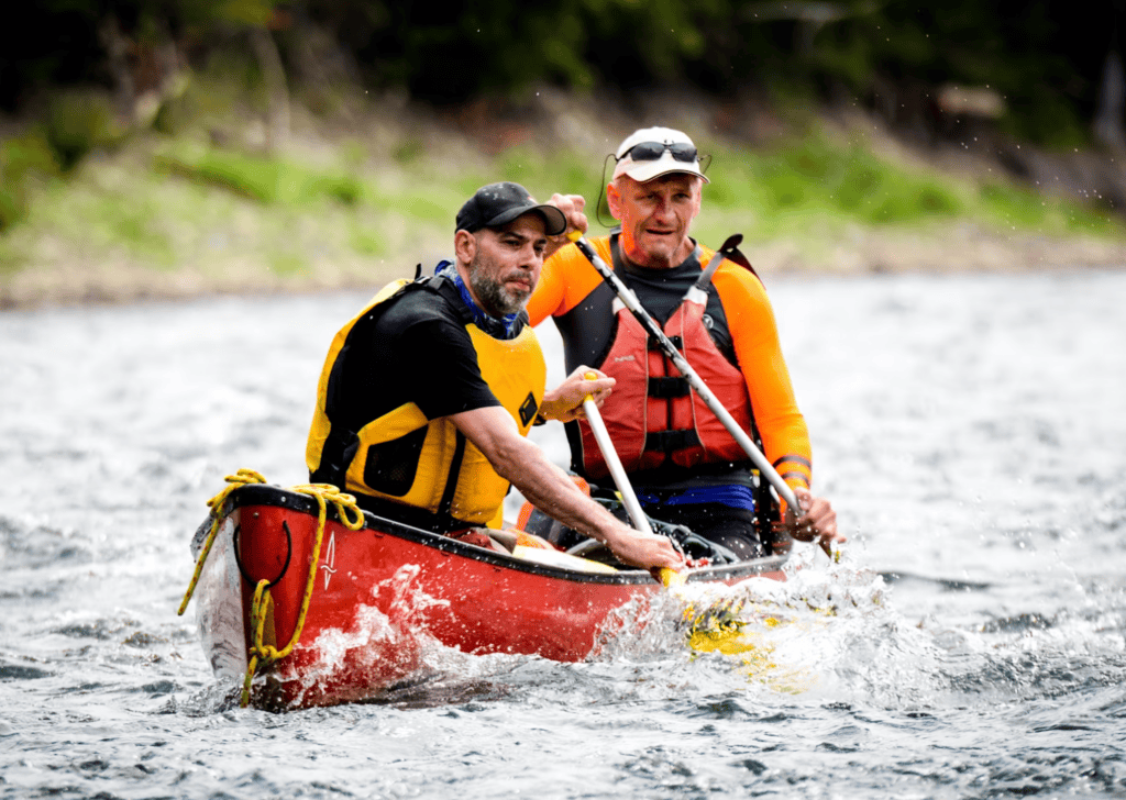 Two men canoeing with life jackets on