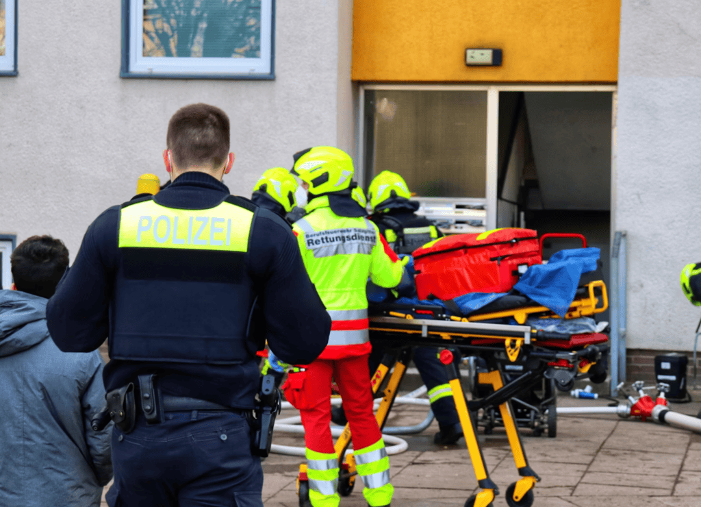 Rescue team and police respond with stretcher outside building
