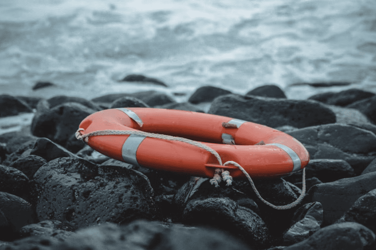 Lifebuoy ring on wet coastal rocks