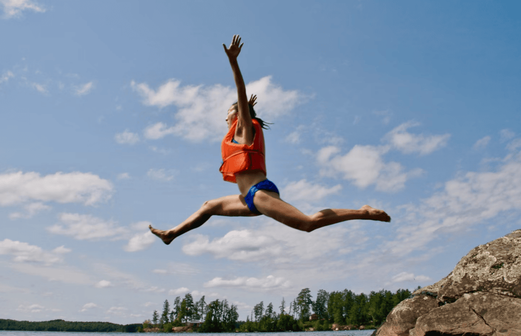 Person Jumping Into Water Wearing Life Jacket