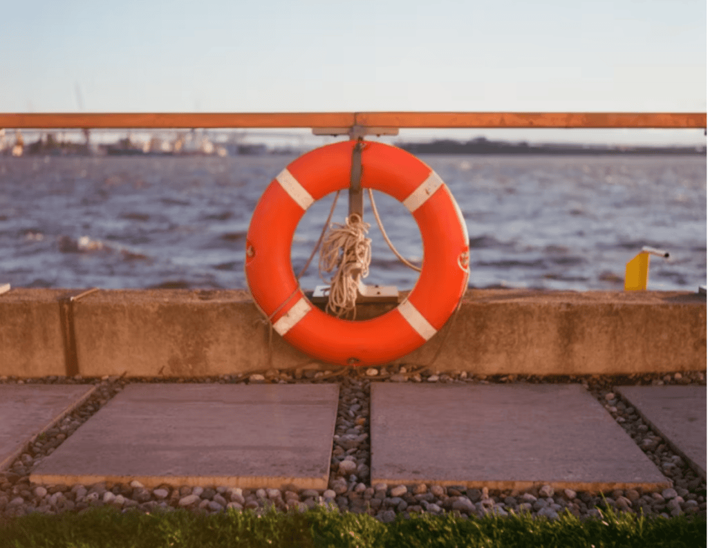 Life Buoy Hanging on Riverside Rail at Sunset