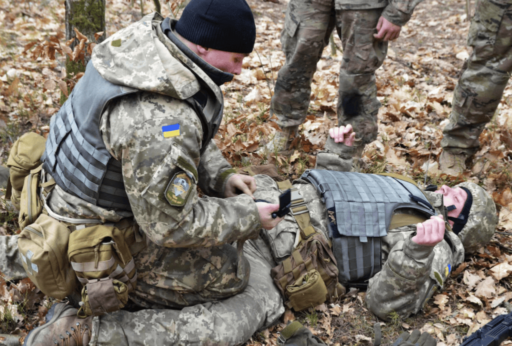Soldier applying tourniquet in battlefield situation