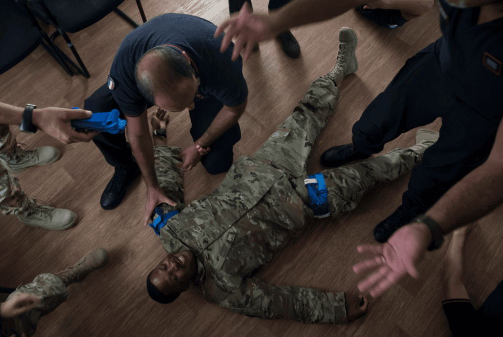 Tourniquet training on soldier during medical drill