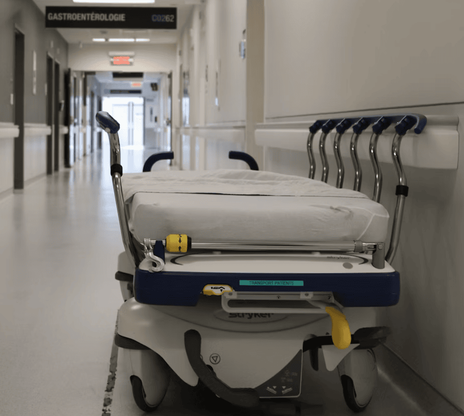 Empty hospital stretcher in a clean hallway, ready for patient transport in medical emergencies or routine care.