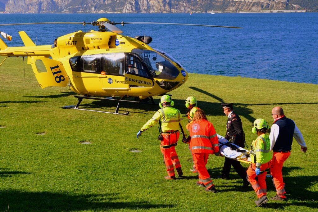 Emergency air rescue team loading patient onto helicopter stretcher