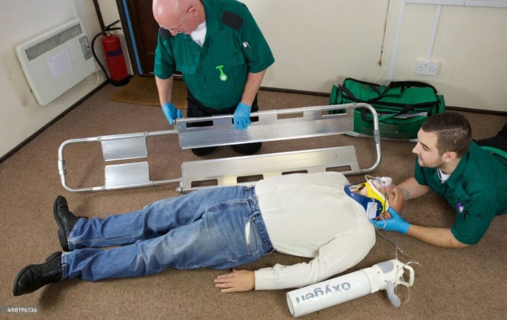 Emergency team using scoop stretcher to immobilize patient during first aid